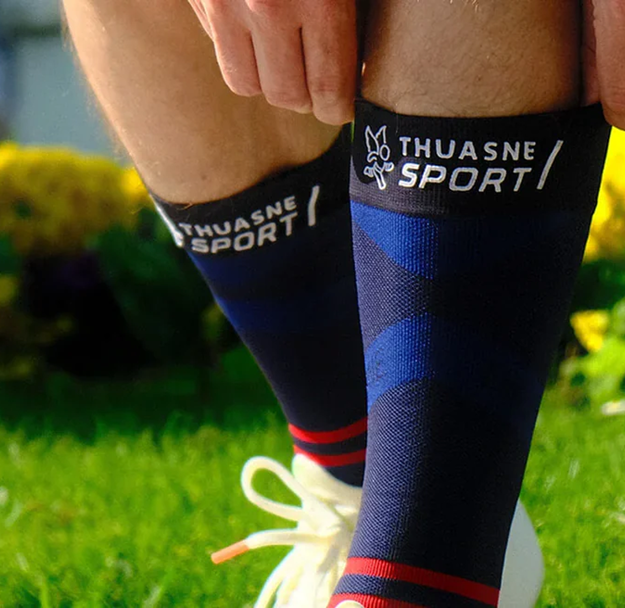 Sportif enfilant une chaussette de compression Thuasne Sport bleu foncé
