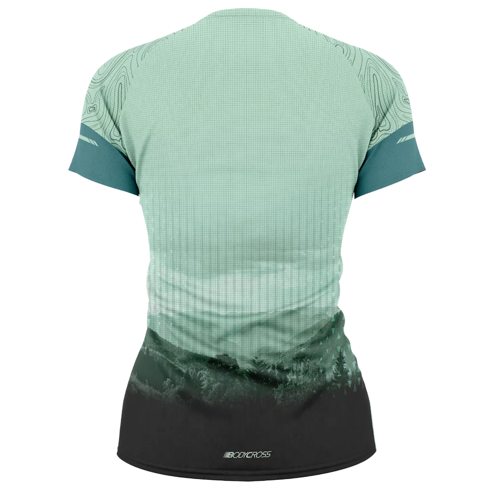 Tee-shirt running trail femme BODYCROSS Cleore bleu clair et vert vue de dos avec imprimé paysage montagne et forêt