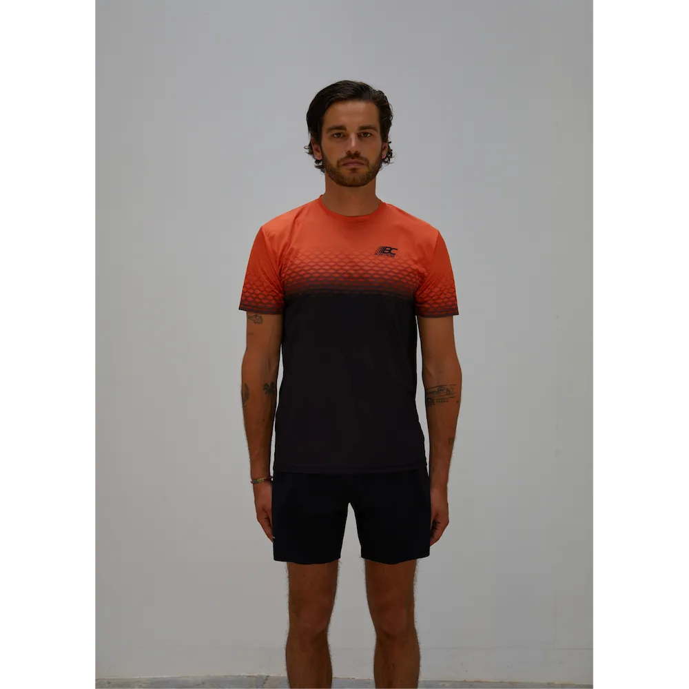 Tee-shirt running homme BODYCROSS Djoe orange et noir porté de face avec motif graphique sur la poitrine