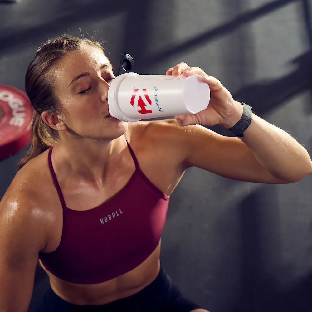 Athlète buvant un shaker de protéines Dymatize après son entraînement