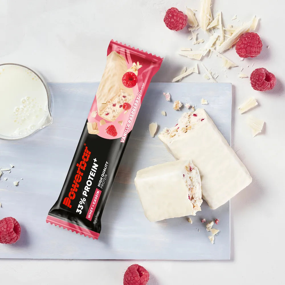 Barre protéinée Powerbar 33% Protein+ Vanille-framboise ouverte avec enrobage blanc et morceaux de framboise