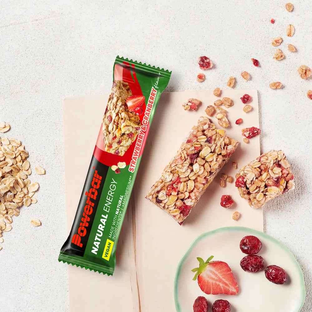 Barre vegan Powerbar Natural Energy Fraise-canneberge ouverte et coupée avec flocons d'avoine, fraises et canneberges