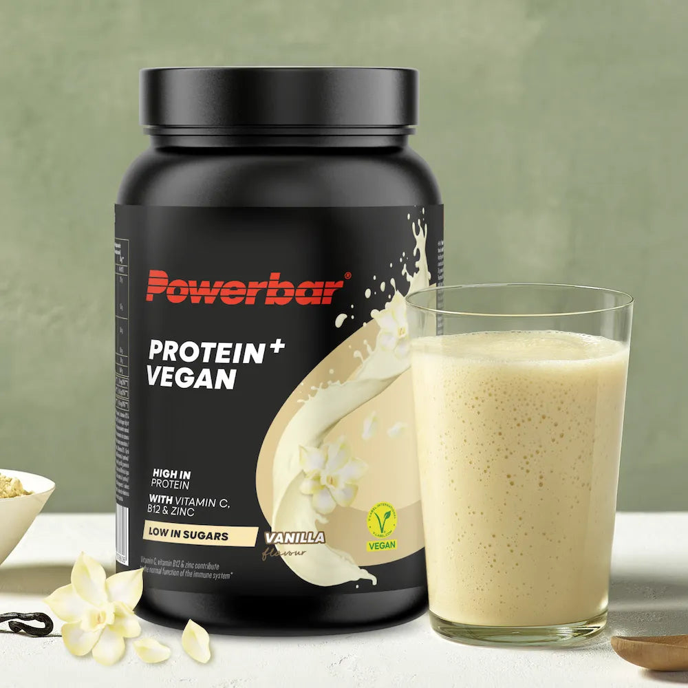 Powerbar Protein+ Vegan vanille avec verre de boisson protéinée végétale préparée
