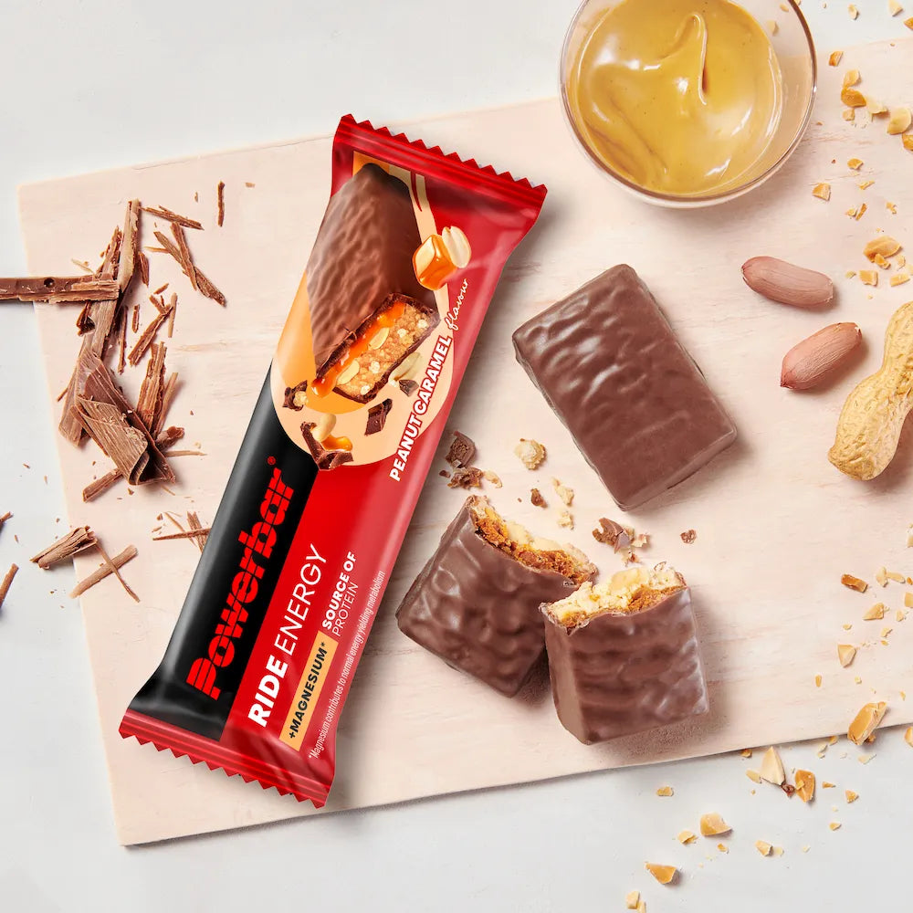 Barre Powerbar Ride Energy Cacahuètes-caramel ouverte et coupée avec caramel, chocolat et cacahuètes