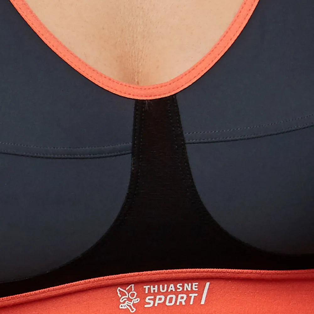 Détail des bonnets et du logo Thuasne Sport sur la bande corail de la brassière Activ Sport Bra