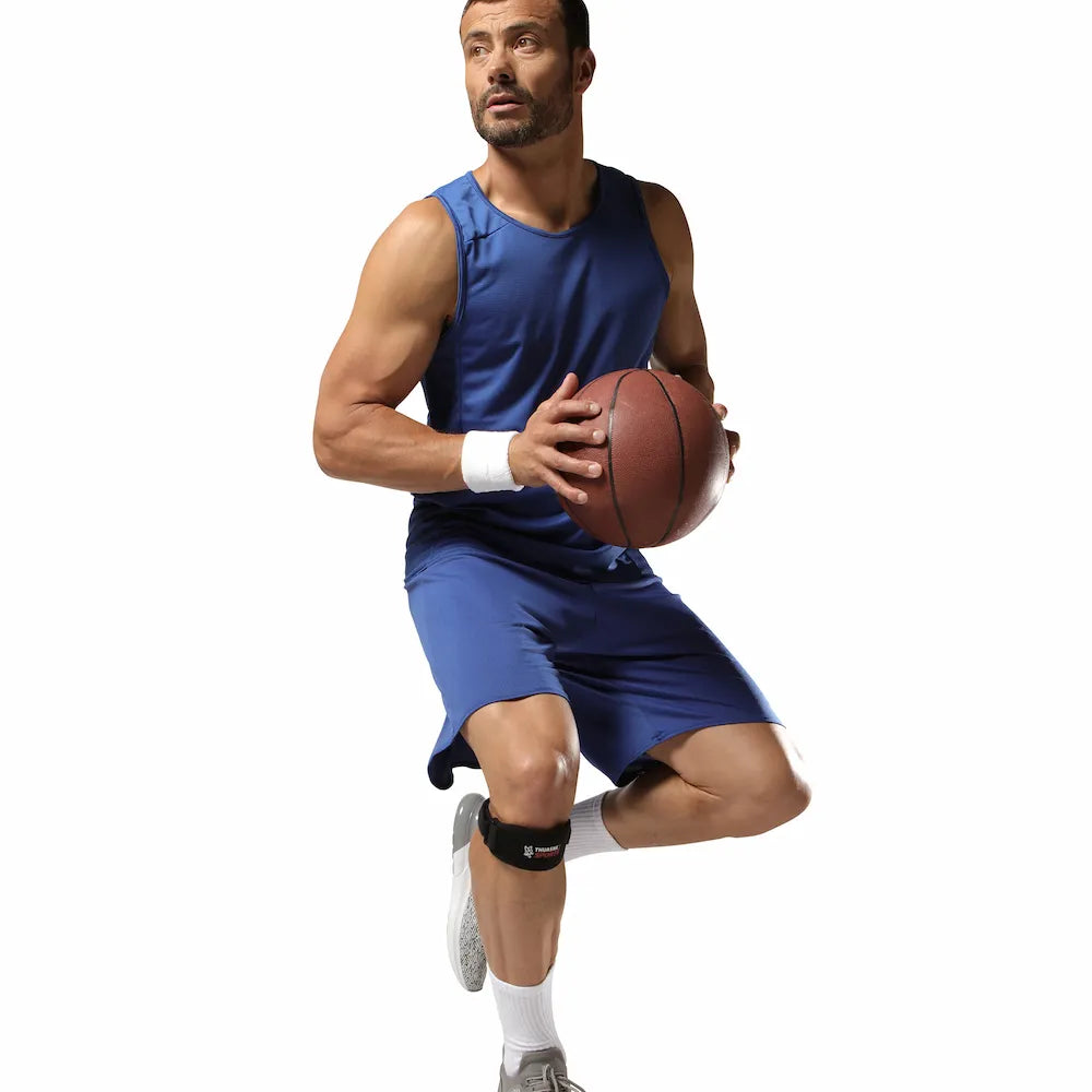 Basketteur en mouvement portant un bandage rotulien Thuasne Sport noir