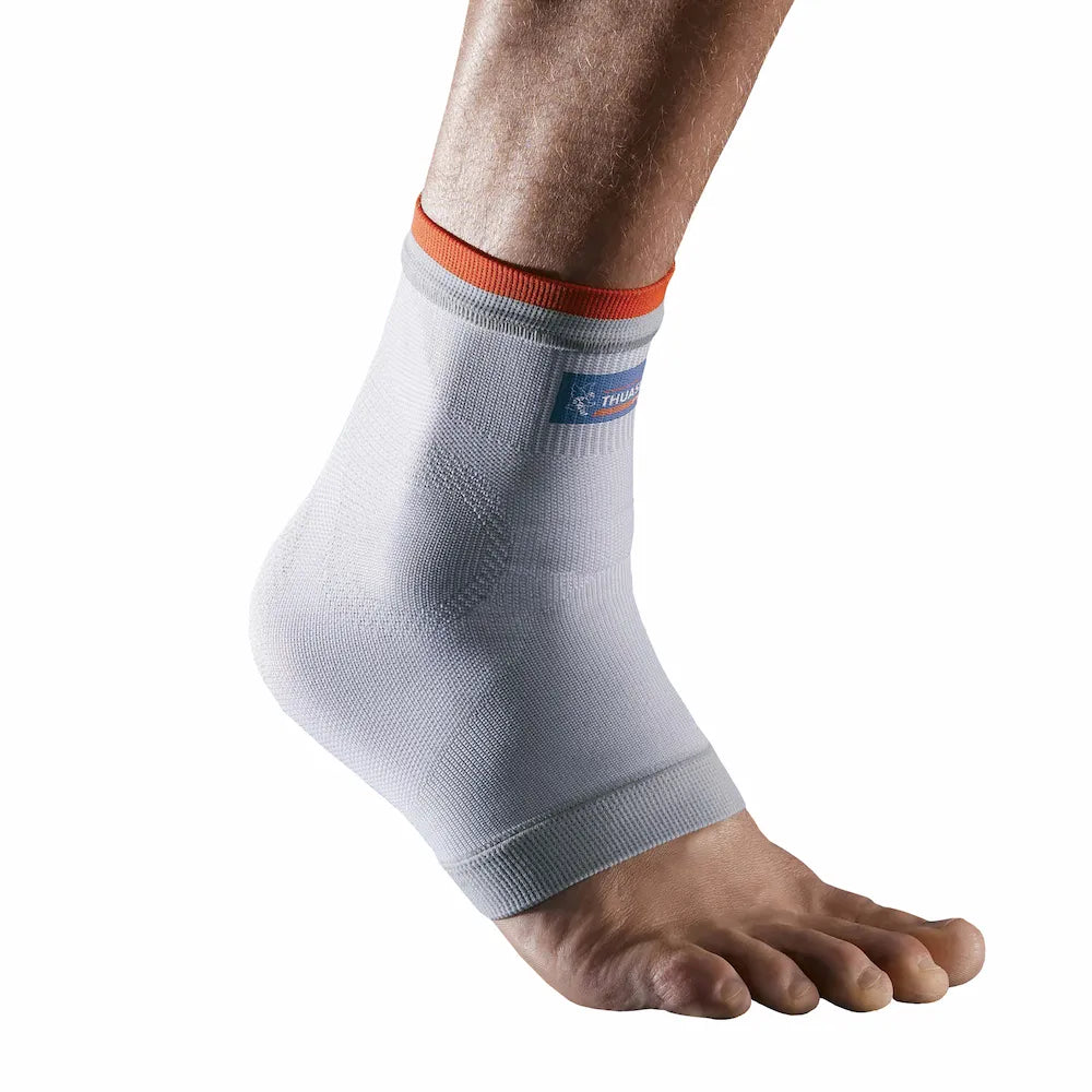 Chevillère de maintien intégral Thuasne Sport Stabilité 2 portée sur fond blanc avec tricot compressif gris clair