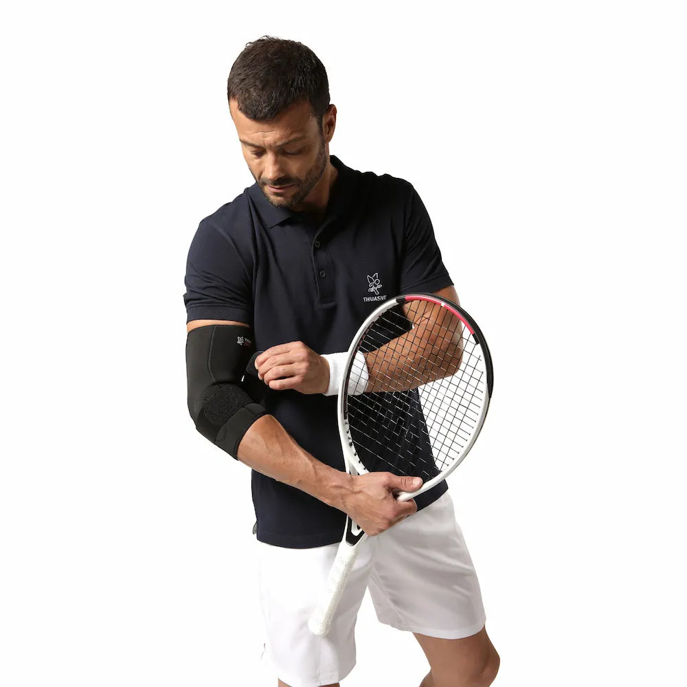 Homme portant la coudière épicondylite Thuasne Sport avec une raquette