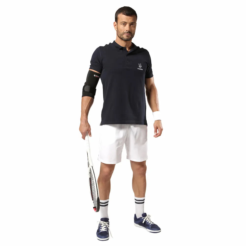 Sportif debout portant une coudière épicondylite Thuasne Sport noire