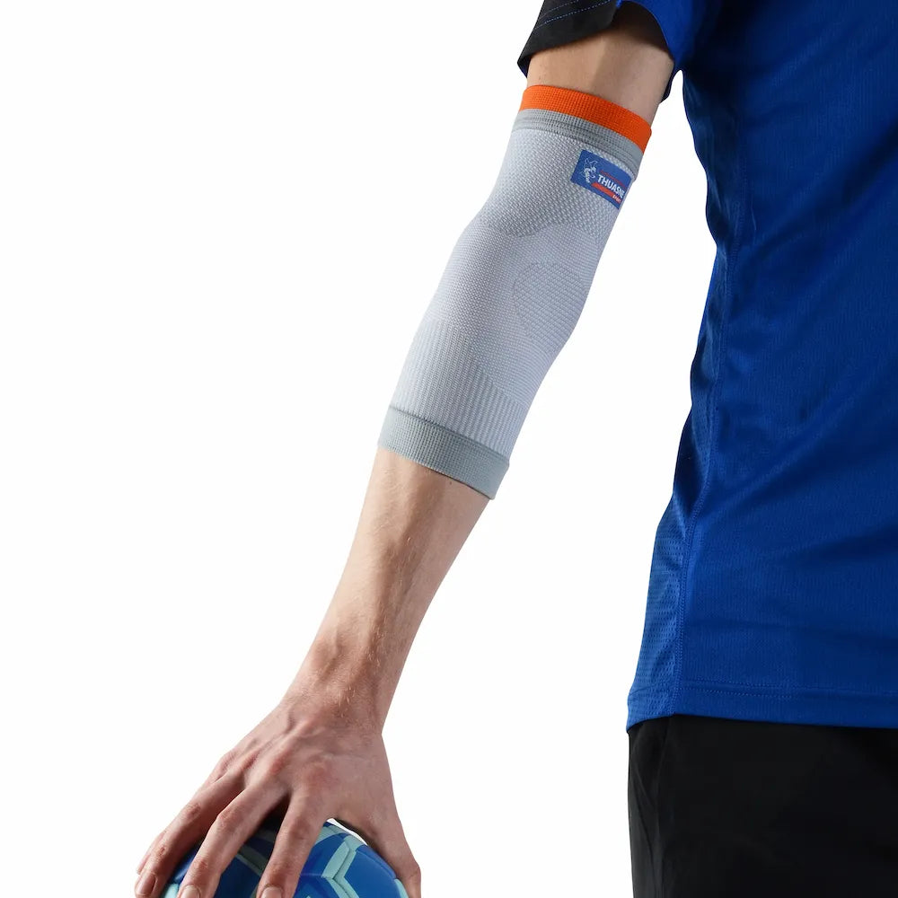 Coudière de maintien Thuasne Sport Stabilité 2 grise portée sur un bras tendu avec bordure orange